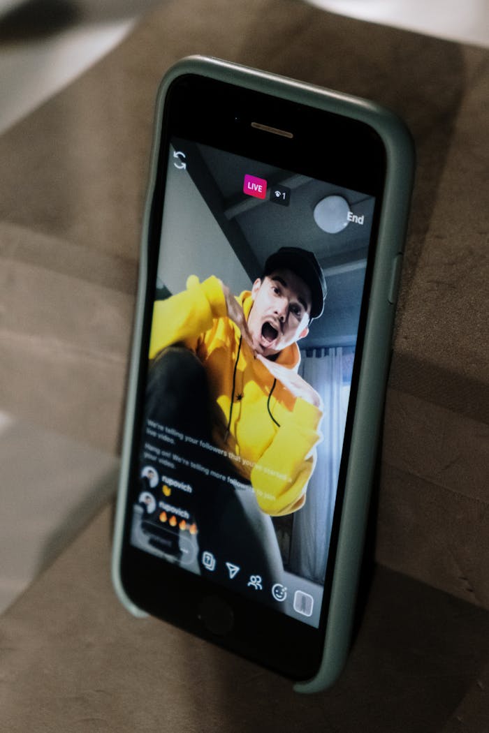 A man enthusiastically interacting on a live social media session via smartphone.